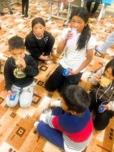 5 Kinder sitzen im Kreis und trinken Saft